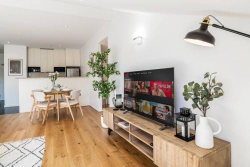 a living room with a flat screen tv on a wall at Bright stylish gem in central Melbourne in Melbourne
