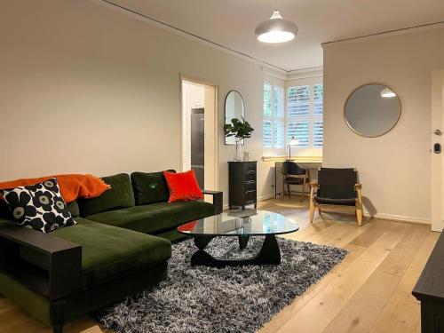 a living room with a green couch and a glass table at Affordable Luxury - CBD Wagga in Wagga Wagga