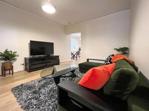 a living room with a couch and a flat screen tv at Affordable Luxury - CBD Wagga in Wagga Wagga