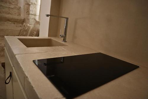 a bathroom with a sink and a counter with a tap at Suite Dimora Antico Campanile in Locorotondo