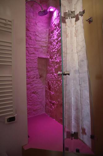 a bathroom with a shower with purple lighting at Suite Dimora Antico Campanile in Locorotondo