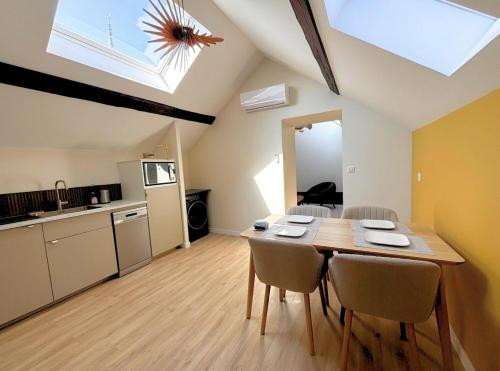 une cuisine et une salle à manger avec une table et des chaises dans l'établissement L'échapée verte Grand T3 avec climatisation, à Lons-le-Saunier