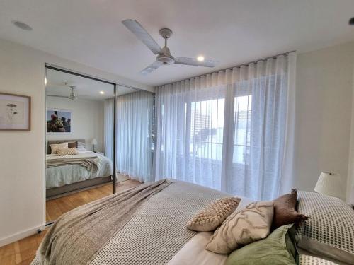 a bedroom with a large bed and a large mirror at Regent Retreat Top floor apartment in Melbourne