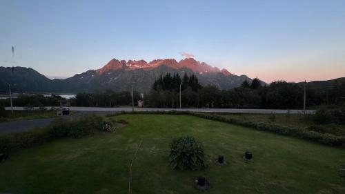 a field of grass with a mountain in the background at Apartment Vestpollen in Vestpollen