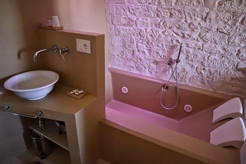 a bathroom with a sink and a bath tub with a toilet at Suite Dimora Antico Campanile in Locorotondo
