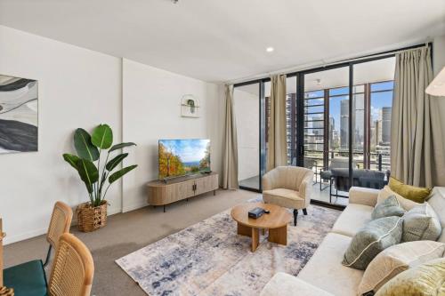 a living room with a couch and a tv at Unbeatable River and CBD Views Pool 2Car and Prime Spot in Brisbane