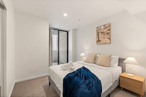 a bedroom with a large bed with a blue blanket on it at Unbeatable River and CBD Views Pool 2Car and Prime Spot in Brisbane