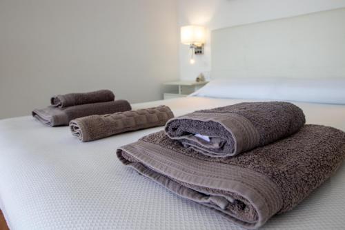a bed with two brown towels on top of it at EL ENCANTO Chiclana II in Chiclana de la Frontera