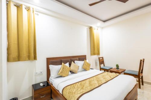 a bedroom with a bed and a chair at Hotel Gill Comfort Inn - Close to MEDANTA, ARTEMIS AND FORTIS HOSPITAL in Gurgaon