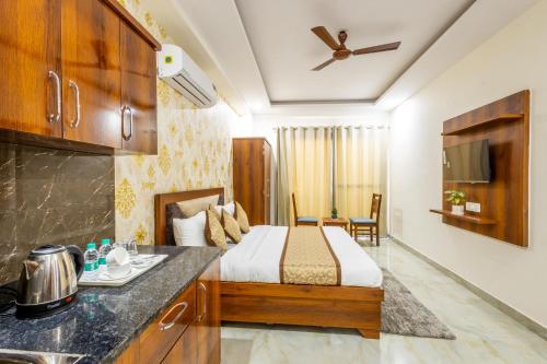 a hotel room with a bed and a kitchen at Hotel Gill Comfort Inn - Close to MEDANTA, ARTEMIS AND FORTIS HOSPITAL in Gurgaon