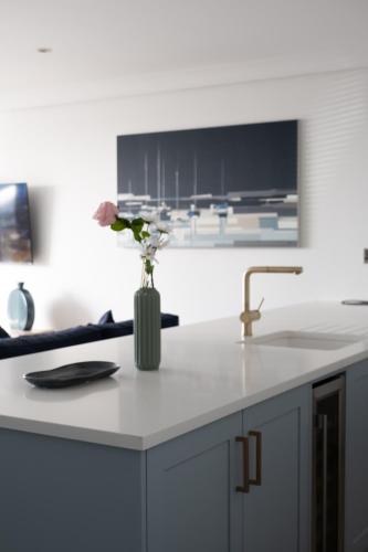 a kitchen counter with a vase with flowers in it at The Pier Portrush in Portrush