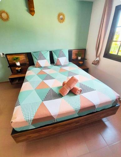 a bed with two pillows on it in a room at L'abri côtier in Port-Louis
