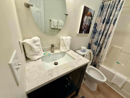 a bathroom with a sink and a toilet and a mirror at 2Br 2Ba Condo on Golf Course in Pawleys Island