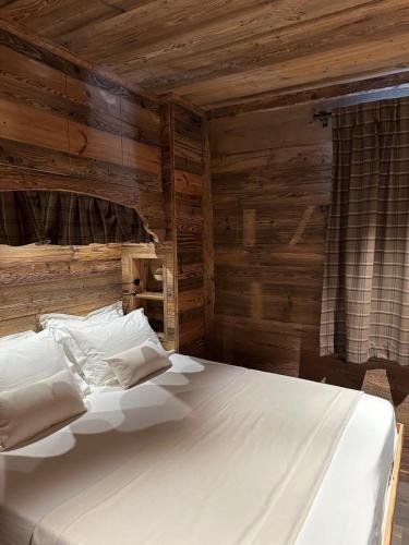 Cette chambre comprend un grand lit blanc. dans l'établissement les 2 ours, à Val dʼIsère
