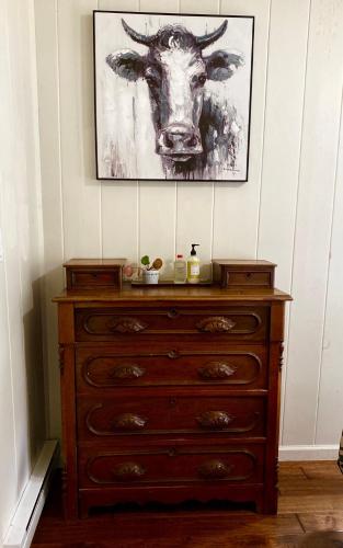 a dresser with a picture of a cow on the wall at Relaxing Farm Retreat- Fresh Eggs with Every Stay! in Gig Harbor
