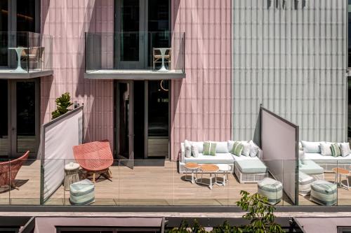 a patio with couches and chairs on a building at The Ray Hotel Delray Beach, Curio Collection By Hilton in Delray Beach