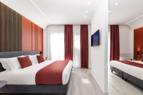 una camera d'albergo con due letti e una televisione di St Peter Twelve a Roma