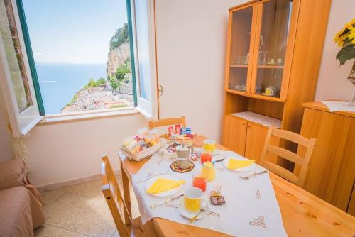 a dining room with a table with a view of the ocean at Casa Adele Pogerola in Amalfi