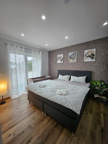 a bedroom with a large bed with a wooden floor at Ferienwohnung in Bad Laasphe