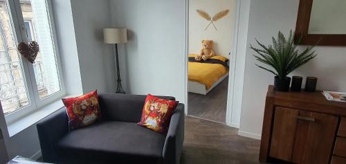 - un salon avec un canapé et un ours en peluche sur un lit dans l'établissement Lumineux & Convivial, à Bourges