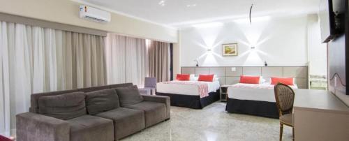 a hotel room with a couch and two beds at Cassino All Inclusive Resort Poços de Caldas By Nacional Inn in Poços de Caldas