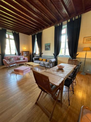 un grand salon avec une table et des chaises dans l'établissement Le Jardin du Clocheton, jardin et parkings privés, centre Etretat, à Étretat