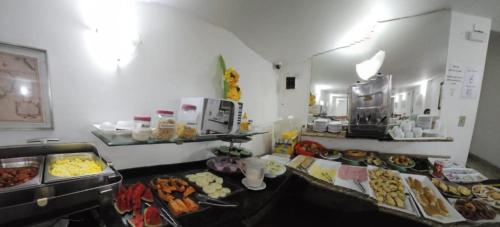 um buffet com muitos tipos diferentes de comida em Dublin Hotel em São Paulo