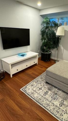 a living room with a flat screen tv and a bed at Bayview Bed and Breakfast in Mill Bay