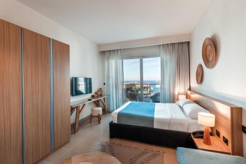 a bedroom with a bed and a desk and a window at Redcon Suites in Hurghada