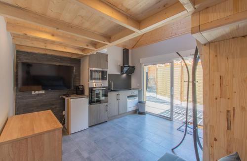 Il comprend une cuisine dotée de plafonds en bois et d'une grande fenêtre. dans l'établissement Apartment type f1 to, à Sainte-Hélène-sur-Isère