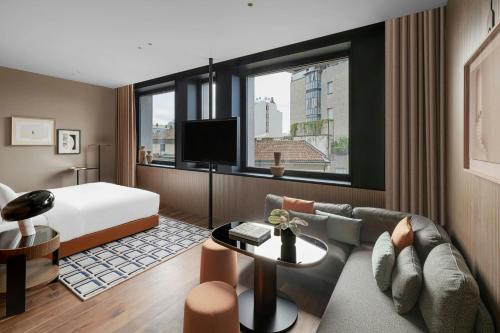 a hotel room with a bed and a couch at Casa Brera, a Luxury Collection Hotel, Milan in Milan