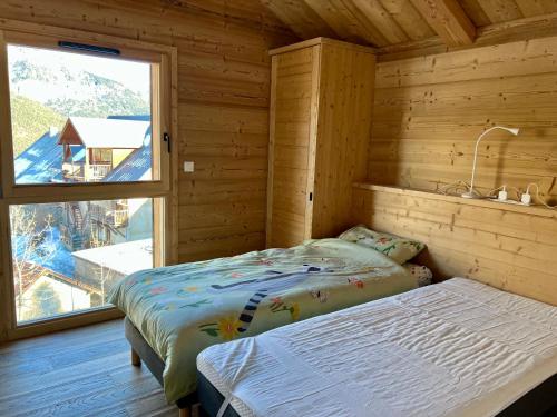 une chambre avec un lit et une grande fenêtre dans l'établissement Chalet Neuf 12 pers Ski au pied, Cinéma, à Puy-Saint-Vincent