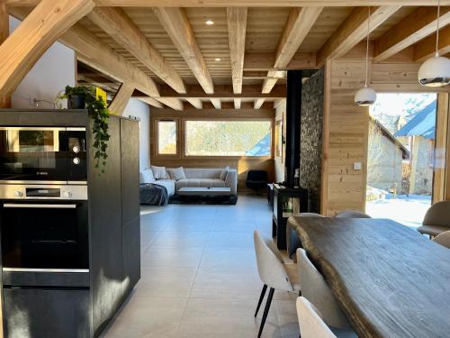 Il dispose d'une cuisine et d'un salon avec un plafond en bois. dans l'établissement Chalet Neuf 12 pers Ski au pied, Cinéma, à Puy-Saint-Vincent