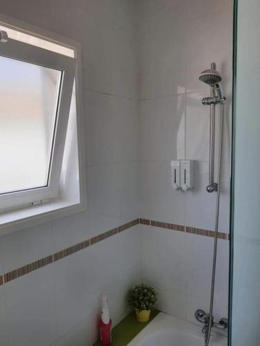 a bathroom with a shower and a sink with a window at Villa Feliza in Güime