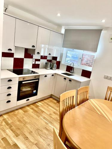 a kitchen with a wooden table and a wooden floor at Oxford city centre Modern 2-Bed flat in Oxford
