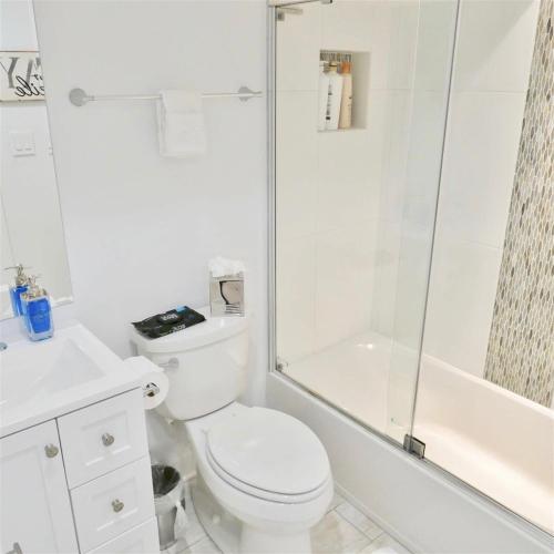 a white bathroom with a toilet and a shower at Stylish & Modern Apt Shaw PKING in Washington, D.C.