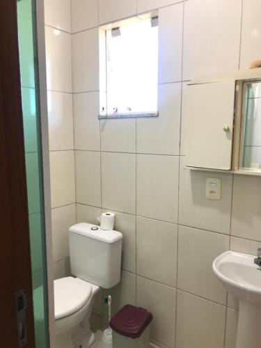a bathroom with a toilet and a sink at Espaço Baobá Suítes Confortáveis in Camboriú