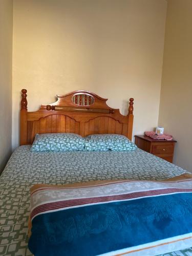 a bed with a wooden headboard in a bedroom at Hotel Casa Eduardo Martinez in Santiago Matatlán