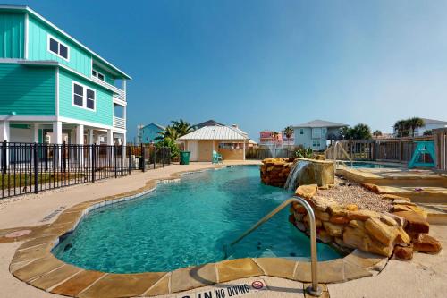 a pool with a water slide in a yard at Bella Vista & Four Winds House in Padre Island