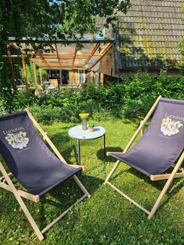 two folding chairs and a table in the grass at Chalet 190 La Belle Durbuy in Durbuy
