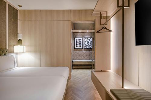 a bedroom with a bed and a window and a chair at AC Hotel Milano by Marriott in Milan