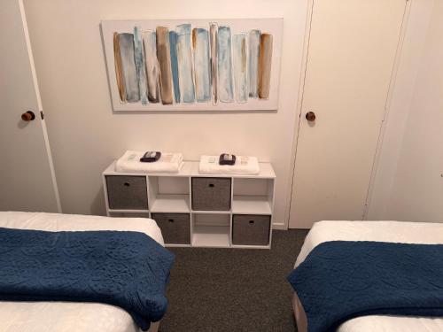 a room with two beds and a table with mirrors at Wairoa Motel in Wairoa