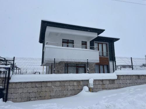 a house with snow on the ground in front of it at Villa Efes in Hisarcık