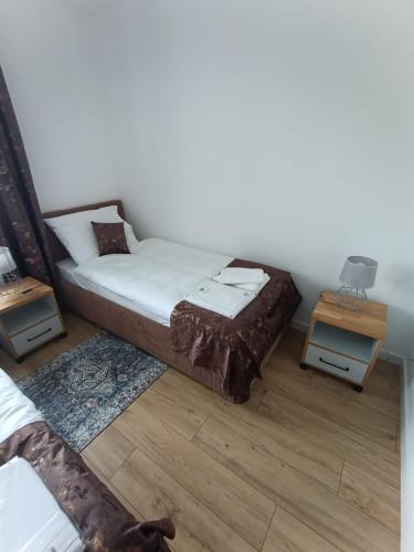 a bedroom with a bed and two night stands at Apartamenty Noclegowe U Bartosza in Odrzechowa