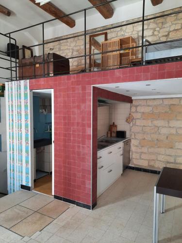 - une cuisine avec un mur en carrelage rouge dans l'établissement Atypical apartment in Sète, à Sète