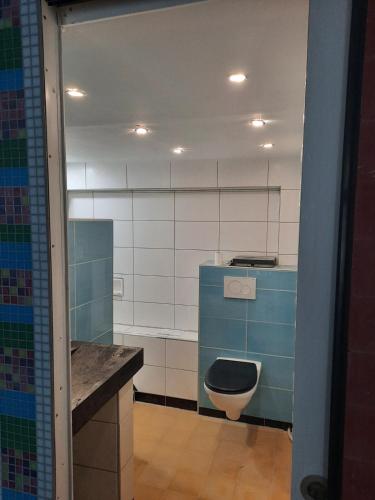 une salle de bain avec des toilettes bleues et un lavabo dans l'établissement Atypical apartment in Sète, à Sète
