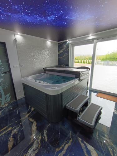 a jacuzzi tub in a room with a star ceiling at Apartamenty Noclegowe U Bartosza in Odrzechowa