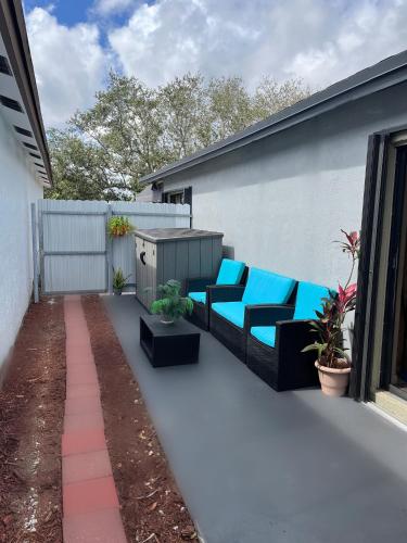 a patio with blue chairs and plants on a building at Amazing & cozy Duplex near Zoo Miami ! in Miami