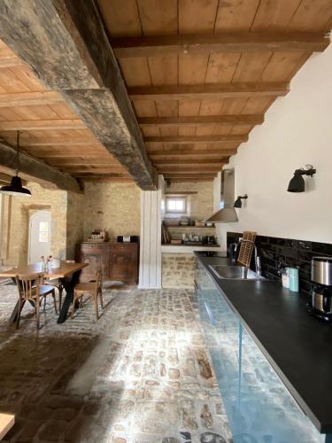 une cuisine avec une table et une salle à manger dans l'établissement Ferme Hay Day, à Asnières-en-Bessin