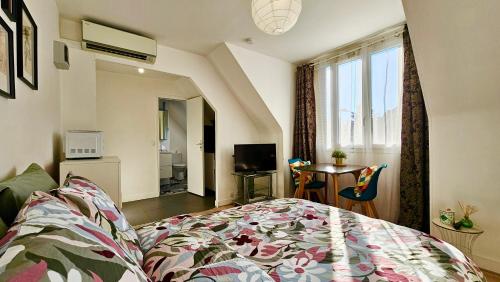 une chambre avec un lit, une table et une fenêtre dans l'établissement Studio Lavande - 15min Paris RER E, cosy, à Noisy-le-Sec